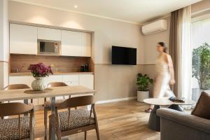 a woman is walking through a living room at Rota Suites in Rota d'Imagna