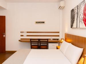 a bedroom with a bed and a table and chairs at Ville de Montagne Hotel in Brumadinho