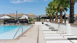 a swimming pool with chaise lounge chairs and palm trees at Desert View in Long Valleu in Washington