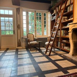 a room with a fireplace and a book shelf at Maisons d'antan Giverny in Giverny