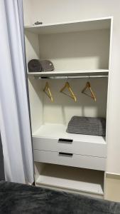 a white closet with hangers and towels in it at Apartamento completo, moderno e bem localizado in Parnamirim +34 photos