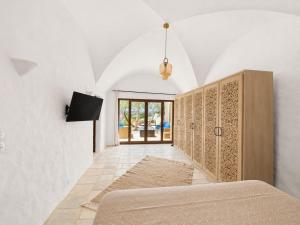 a bedroom with a bed and a tv on a wall at Maisonnette Olea Hammamet in Hammamet +15 photos