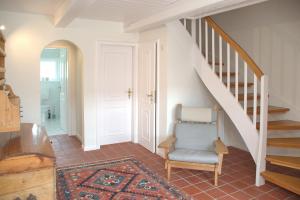 a stairway with a blue chair in a room at Van Gunst Hüs, Alkersum in Alkersum