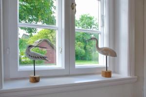 two statues of birds sitting on a window sill at Van Gunst Hüs, Alkersum in Alkersum