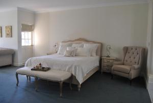 a bedroom with a large bed and a chair at Peel Manor House in Karnup