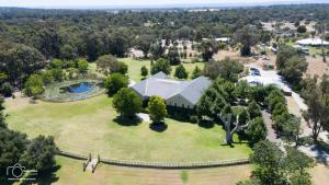an aerial view of a house on a large green field at Peel Manor House in Karnup