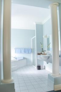 a white bathroom with a sink and a mirror at Peel Manor House in Karnup +3 photos