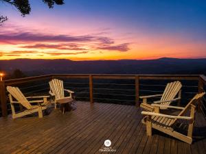 two chairs sitting on a deck watching the sunset at Rancho Sol Poente - Rancho Queimado - SC in Rancho Queimado