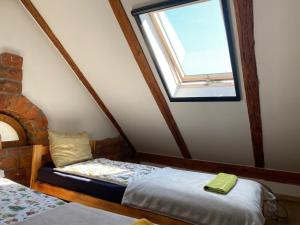 a attic room with a bed and a window at SARNOGRÓD - Agroturystyka z alpakami in Babięta