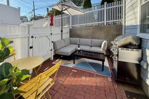 a patio with a couch and a table and a chair at Helltown Hideaway - Private Patio, Walk Anywhere, Free Parking in Provincetown