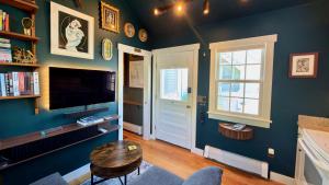 a living room with blue walls and a table and a tv at Helltown Hideaway - Private Patio, Walk Anywhere, Free Parking in Provincetown