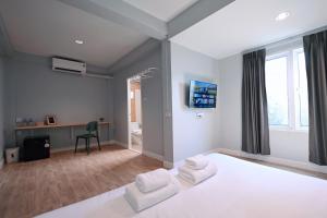 a bedroom with a bed with two white chairs at Stay C Hotel in Ban Samet