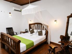 a bedroom with a wooden bed with a canopy at Sigiri Lion Lodge in Sigiriya