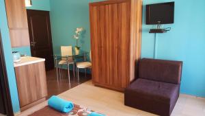 a living room with a chair and a television at Apartment Color Beach in Siófok