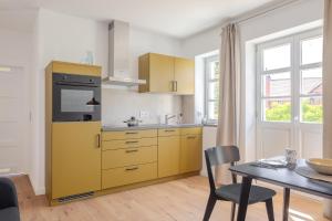 a kitchen with yellow cabinets and a table and chairs at An der Obstwiese in Untergut