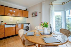 a kitchen and dining room with a wooden table and chairs at 2 Bed in Mumbles oc-hh141 in Newton +25 photos