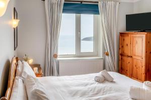 a bedroom with a white bed and a window at 2 Bed in Mumbles oc-hh141 in Newton