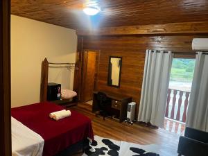 a bedroom with a bed and a window with a balcony at Hotel Pirâmides Sagradas in Grão Pará