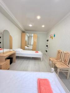 a large room with two beds and a mirror at Jaily in Astana +5 photos
