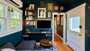 a living room with a couch and a tv on a blue wall at Helltown Hideaway - Private Patio, Walk Anywhere, Free Parking in Provincetown