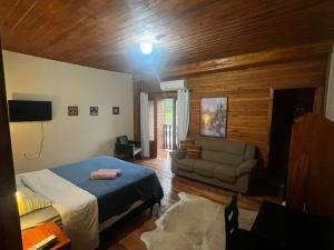 a bedroom with a bed and a couch in it at Hotel Pirâmides Sagradas in Grão Pará +6 photos