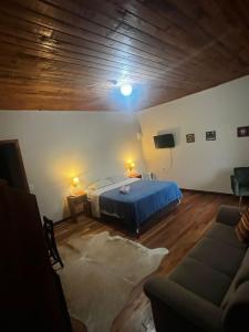a bedroom with a blue bed and a couch at Hotel Pirâmides Sagradas in Grão Pará