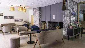 a waiting room with chairs and tables and purple walls at VTF Le Dou De La Ramaz in Montalbert