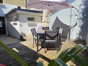 a table and chairs and an umbrella on a deck at La Caloge in Fécamp