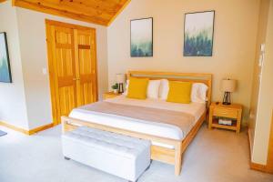 a bedroom with a large bed with yellow pillows at Peaceful Winnipesaukee Retreat, Walking Trails in Wolfeboro