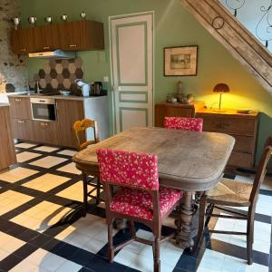 a kitchen with a wooden table and chairs at Maisons d'antan Giverny in Giverny