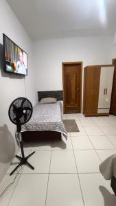 a bedroom with a bed and a tv on the wall at Sobrado Tropical a 1 Km da faculdade Unic e UFMT in Cuiabá