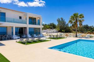a villa with a swimming pool and a resort at Villa Stella Sunset in Nea Dimmata