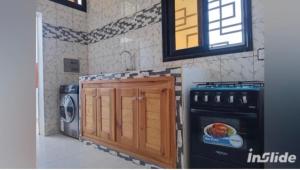 a kitchen with a stove and a washing machine at Perles de ngaparou in Saly Portudal