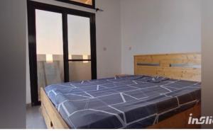 a large blue bed in a room with windows at Perles de ngaparou in Saly Portudal