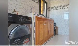 a kitchen with a washing machine in a room at Perles de ngaparou in Saly Portudal +19 photos