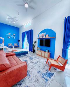 a living room with blue walls and a red couch at Santorini Vibes Penang - Tasek Gelugor in Kampong Selamat