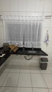 a kitchen with a window and a black counter top at Sobrado Tropical a 1 Km da faculdade Unic e UFMT in Cuiabá +13 photos