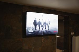 a flat screen tv hanging on a wall at Suite Tentation avec Jacuzzi in Châteauneuf-lès-Martigues