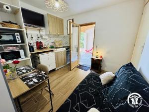 a living room with a couch and a kitchen at L'oustal de sandy in Cascastel-des-Corbières