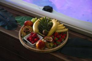 a plate of fruits and vegetables on a table at Suite Tentation avec Jacuzzi in Châteauneuf-lès-Martigues +3 photos