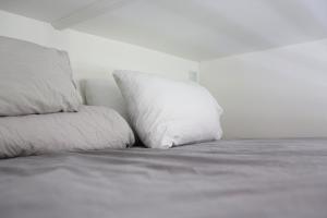 a white bed with two pillows on top of it at Exclusive 1 bedroom apartment in Copenhagen