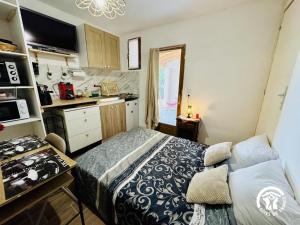 a small kitchen with a bed in a room at L'oustal de sandy in Cascastel-des-Corbières