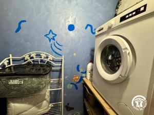 a washing machine in a room with blue writing on the wall at L'oustal de sandy in Cascastel-des-Corbières +9 photos
