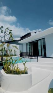 a white house with plants in front of it at Shira Villa in Seturan