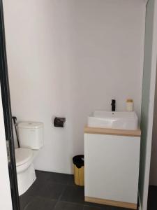 a white bathroom with a toilet and a sink at Shira Villa in Seturan
