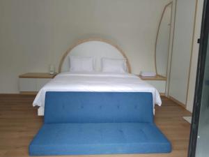 a bed with a blue bench in a room at Shira Villa in Seturan