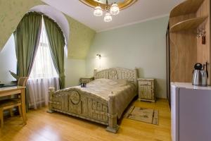 a bedroom with a bed and a table and a window at Barskiye Polati Hotel in Sergiyev Posad