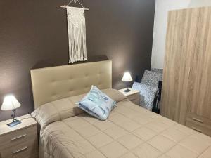 a bedroom with a bed with two night stands and two lamps at Habitación privada con zonas compartidas in Castellbisbal