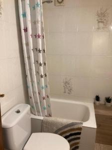 a bathroom with a toilet and a bath tub with a shower curtain at Habitación privada con zonas compartidas in Castellbisbal +6 photos