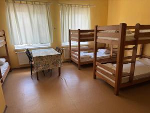 a room with bunk beds and a table and a table and chairs at Guest House KARTA F M in Kamianets-Podilskyi